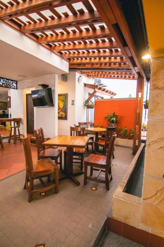 a patio with a table and chairs and a television at Hotel Boutique San Antonio in Cali