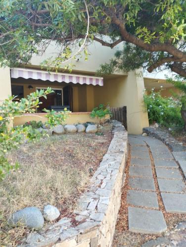 a house with a stone walkway in front of a yard at casa vacanze cettina home 3 mt 50 dal mare in Terra Mala