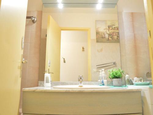 une salle de bain avec un lavabo et un miroir dans l'établissement Villa 4 pièces avec véranda, proche plage, parking privé et BBQ - Saint Pierre la Mer - FR-1-229D-107, à Fleury