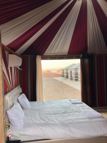 a bed in a tent with a view of the desert at Mira luxury camp in Wadi Rum