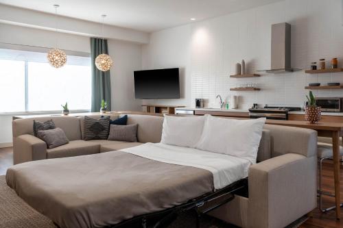 a living room with a couch and a tv at Element Dallas Richardson in Richardson