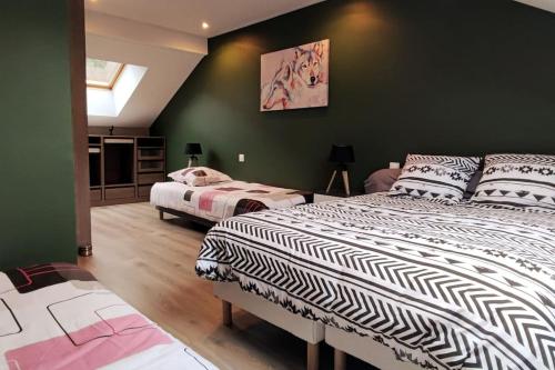 Maison Gite Le Bressaud في لابريس: سريرين في غرفة بجدران خضراء