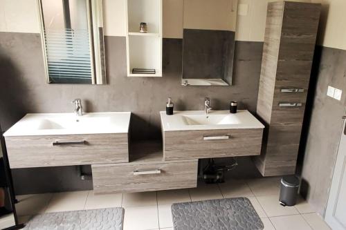 Maison Gite Le Bressaud في لابريس: حمام مغسلتين ومرآة