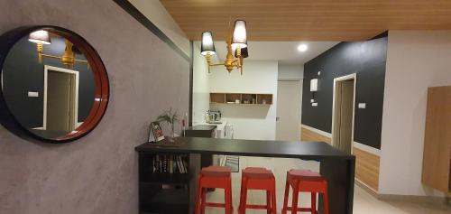 a dining room with a black table and red stools at ARTE plus Jalan Ampang - KLCC in Kuala Lumpur
