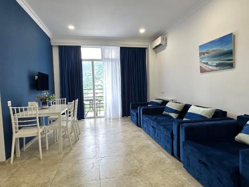 a living room with a blue couch and a table at Blue Apartment in Gonio
