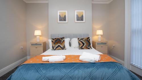a bedroom with a large bed with towels on it at Queens Large 2 BDR & 1 BDR Apartments by Belfast City Breaks in Belfast
