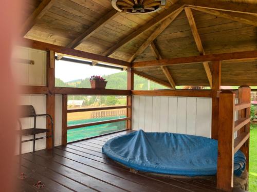 a large wooden porch with a bed on a deck at Aura Karpat in Bukovel