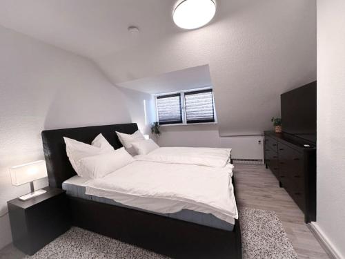 una camera da letto con un letto grande e una televisione di Zentrale Wohnung für 4 mit Bett und Schlafcouch a Essen