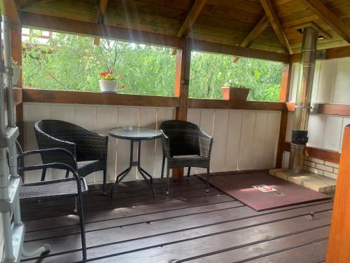 a porch with chairs and a table in a cabin at Aura Karpat in Bukovel
