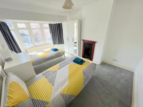 1 dormitorio con 2 camas y chimenea en 4-Bedroom House - South London CR7, en Thornton Heath