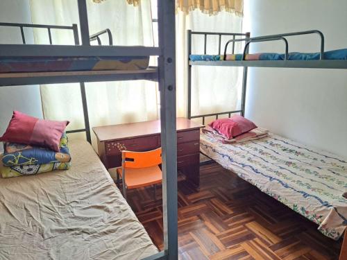 a dorm room with two bunk beds and a desk at Hotel Junio in Quito