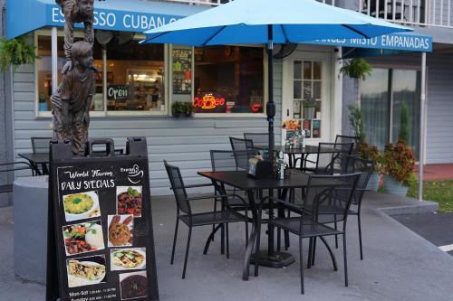 a table and chairs with an umbrella in front of a restaurant at Celebration Suites in Orlando