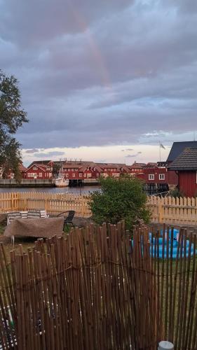 une clôture devant un port avec des maisons rouges dans l'établissement Det kule gule huset, à Svolvær
