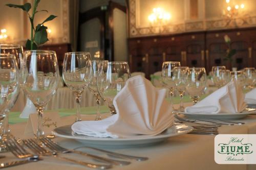 a table with wine glasses and napkins on it at Fiume Hotel in Békéscsaba