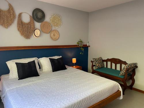 a bedroom with a large bed and a chair at Chalé Litoral Norte - em condomínio de praia in Camaçari