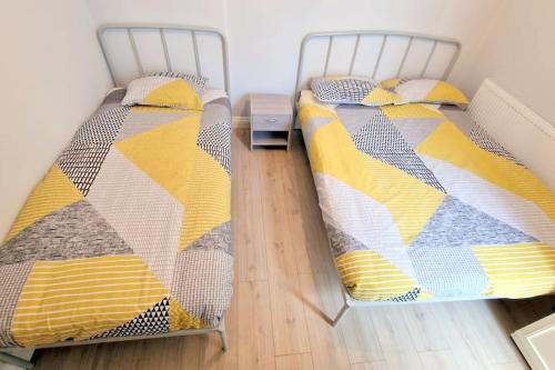 2 aparte bedden op een houten vloer bij Modern 2-bedroom flat in South London in Sutton