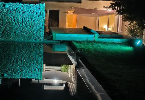 a house with a swimming pool and a garden at night at Mas L'Escale des Dentelles in Aubignan