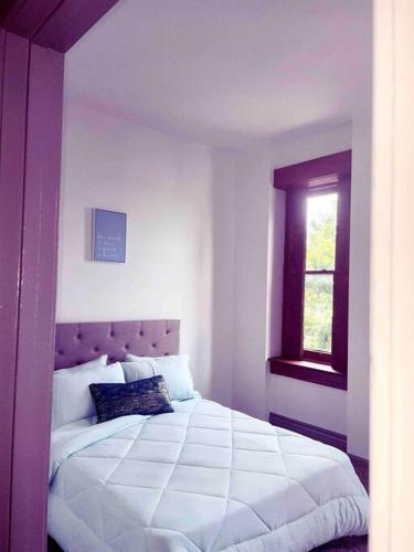 a bedroom with a white bed with a window at 2Br Unit W/ Cinema Room in Nulu in Louisville
