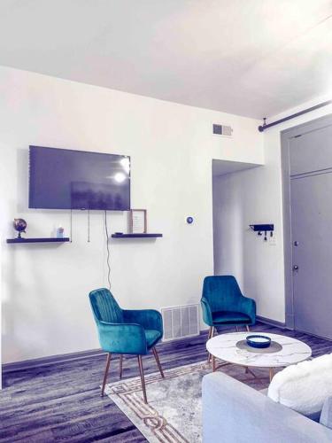 a living room with two chairs and a table at 2Br Unit W/ Cinema Room in Nulu in Louisville