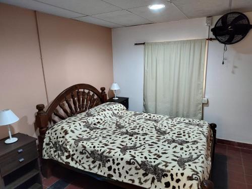 Dormitorio con cama con manta de leopardo en Rinconada 736 Sustentable, en San Salvador de Jujuy