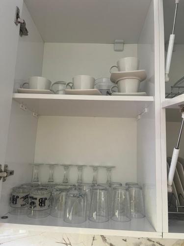 une étagère remplie de plats en verre et de bols dans l'établissement Bujtina Rakaj, à Bogë