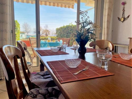 - une table à manger avec des chaises et une table avec vue dans l'établissement Appartement en Rez-de-Jardin, Pieds dans l'Eau, Terrasse, Parking, 4 Couchages - Le Lavandou - FR-1-251-454, au Lavandou