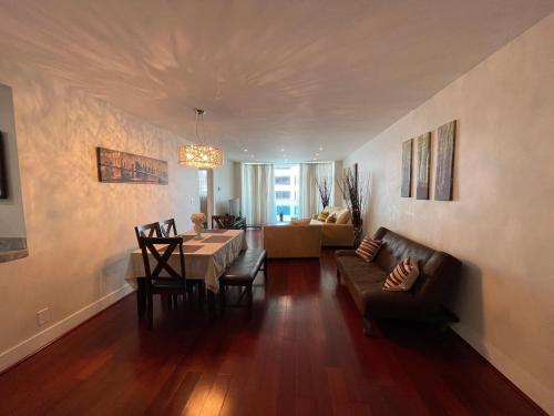 sala de estar con mesa y sofá en 1BR Beachfront Condo in Holywood, FL, en Hollywood