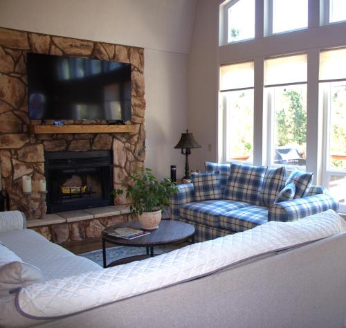 a living room with couches and a stone fireplace at Coastal Retreat Cambria 2 King 1 Queen Bed Fireplace Wi-Fi Free Parking in Cambria