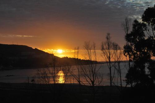 a sunset over a lake with the sun setting at Papudo Laguna Un Lugar Privilegiado in Papudo