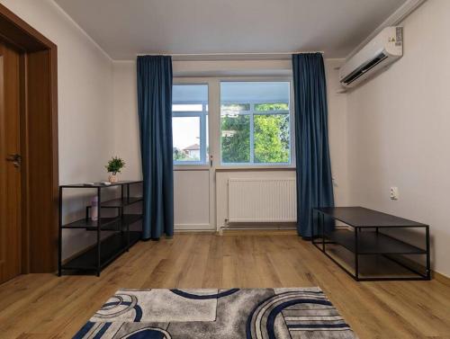 a living room with blue curtains and a window at Cozy Modern Apartment Km 0 Craiova in Craiova