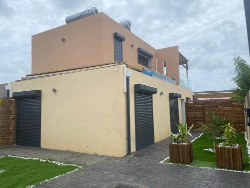 una casa con un garaje delante en Villa Jasmin Standing Piscine Chauffee 4 Ch 9 Pers, en Baie-Mahault