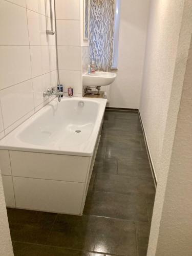 a bathroom with a white tub and a sink at Sauna-Schmied in Weißenfels