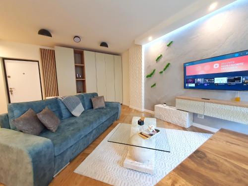 a living room with a couch and a flat screen tv at Lavish Inn Apartment in Cluj-Napoca