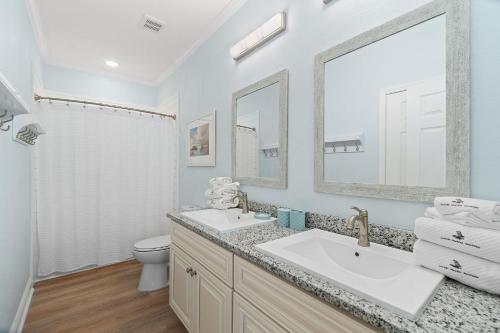 a bathroom with a sink and a toilet and a mirror at Pescador Landing 6A in Pensacola