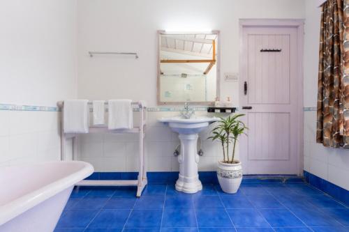 a bathroom with a sink and a mirror and a tub at The Manora Woods Resort - Private Hill Top, Gethiya, Nainital in Nainital