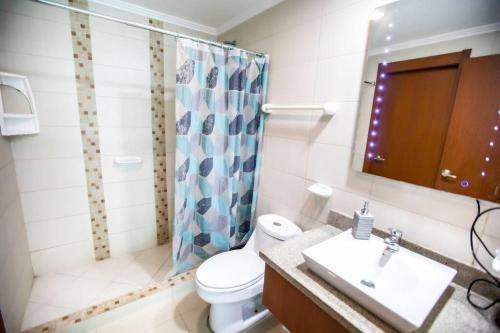 een badkamer met een toilet, een wastafel en een douche bij Suite Vista al río con Balcón en puerto Santa Ana in Guayaquil