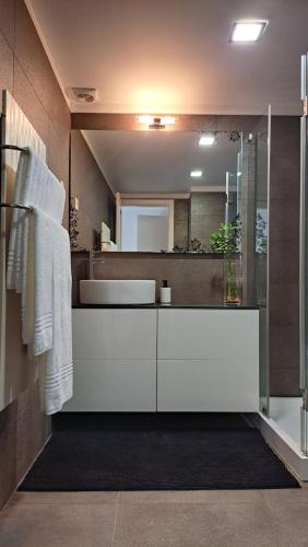 y baño con lavabo blanco y espejo. en Casa da Praça en Miranda do Douro