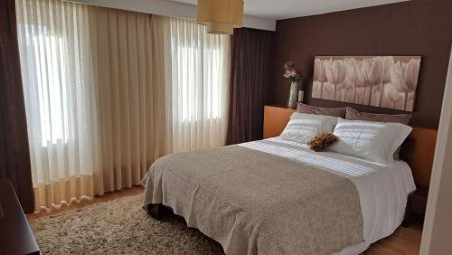 ein Schlafzimmer mit einem Bett mit einem Teddybär drauf in der Unterkunft Casa da Praça in Miranda do Douro