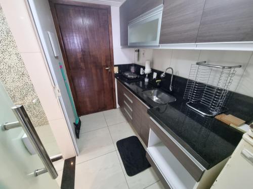a small kitchen with a sink and a counter at DerSalvador Sol Victoria Marina Studios in Salvador