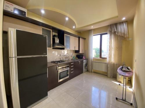 cocina con nevera negra y ventana en LARGE 5 BEDROOM LUXURY VILLA, en Ereván