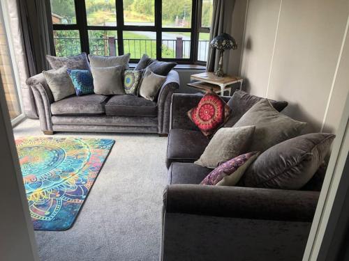 a living room with two couches and a rug at Couple’s Lodge With Hot Tub in Lincolnshire