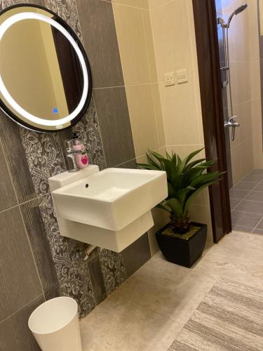 a bathroom with a white sink and a mirror at استديو عائلي بمدخل خاص ودخول ذاتي in Riyadh Al Khabra