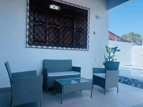 um grupo de cadeiras e uma mesa num quarto em Casa aconchegante com piscina em Macapá