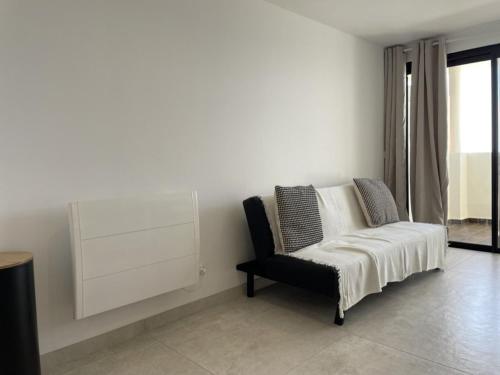 un salon avec une chaise et une fenêtre dans l'établissement Studio cabine avec terrasse, piscine et parking près de la plage Cannes la Bocca - FR-1-609-74, à Cannes