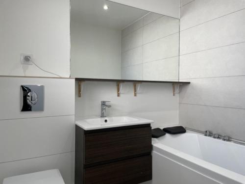 une salle de bain blanche avec un lavabo et une baignoire dans l'établissement Studio cabine avec terrasse, piscine et parking près de la plage Cannes la Bocca - FR-1-609-74, à Cannes