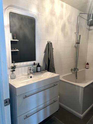 a bathroom with a sink and a tub and a mirror at Lovely Penthouse downtown with 3 bedrooms in Akureyri
