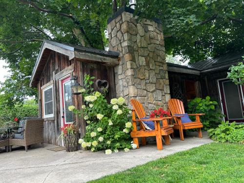 two chairs and a table in front of a cabin at Cozy Guest House close to Wasaga Beach & Blue Mtn in Nottawa
