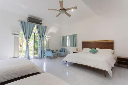 1 dormitorio con 2 camas y ventilador de techo en Cancun Family ideal Villa, private pool and garden en Cancún