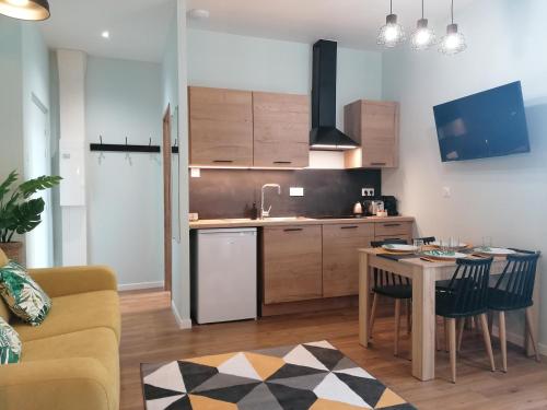 a kitchen and dining room with a table and chairs at Suite Monstera by Welk'Home Inn - Appartement Premium - Troyes Centre in Troyes