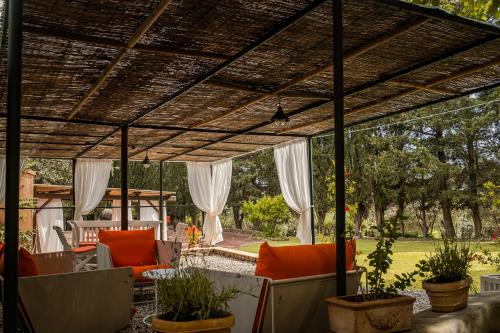 an outdoor patio with a pergola and chairs at MONOLOCALE CASENUOVE con GIARDINO in Castiglioncello